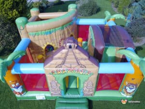 Bright jungle themed inflatable with slide ball pit and bounce area.