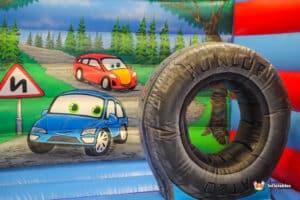 In the middle of a vibrant bouncy castle, a tire is prominently displayed, showcasing the "Auto Bouncer" theme.