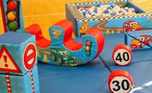 A colorful inflatable play area featuring traffic signs, playful cars, and soft obstacles for children's imaginative play.