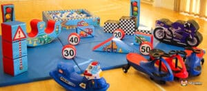 A colorful indoor play area featuring toy vehicles, traffic signs, and a ball pit, designed for children's imaginative play.