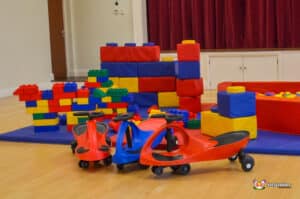 Colorful play area with stacking blocks, soft play structures, and ride-on toys, designed for children's fun and development.