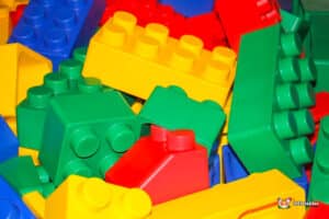 A colorful assortment of plastic building blocks in various shapes and sizes, including red, blue, green, and yellow pieces.