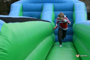 A boy races down an inflatable bungee run, capturing the fun of the playful activity.