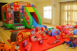 A bouncy castle with soft play shapes set out for children to enjoy at a party.