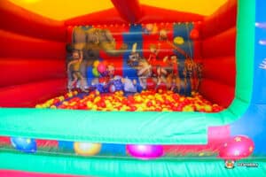 A lively bouncy castle accompanied by a large inflatable ball pit, creating an exciting play area for kids.