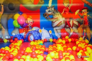A vibrant bouncy castle with a spacious inflatable ball pit, designed for children's entertainment and active play.