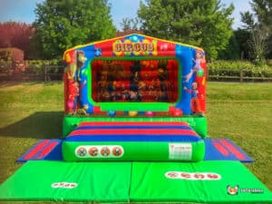 A colorful bouncy castle featuring a cheerful clown, inviting children to jump and play in a festive atmosphere.