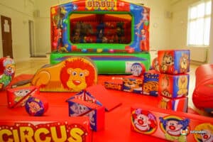 1. Circus-themed bouncy castle featuring a lion, elephant, and other animals, accompanied by matching soft play equipment