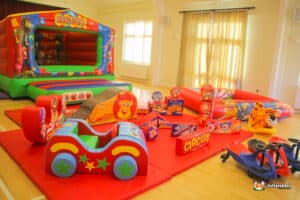 Colorful circus-themed bouncy castle adorned with a lion, elephant, and various animals, alongside soft play items.