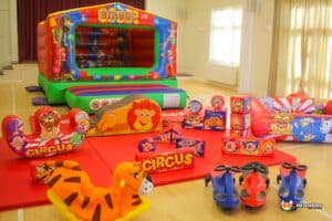 3. A vibrant circus-themed bouncy castle showcasing a lion, elephant, and other animals, with matching soft play elements