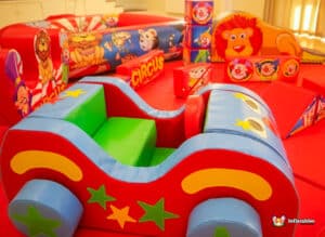 A vibrant circus-themed soft play area filled with diverse toys for kids to play with and have fun.