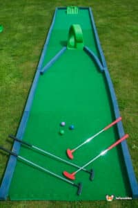 A colourful miniature golf course with a lush green putting green,