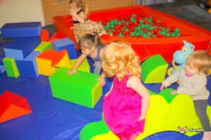Kids engaged in play with vibrant blocks in a soft play area, featuring a ball pool but no bouncy castle.