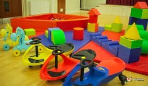 A colorful play area showcasing a large green and blue building, designed for children to engage in soft play fun.