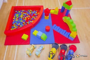 A vibrant play area with soft toys scattered around and a ball pool, perfect for imaginative play and fun activities.