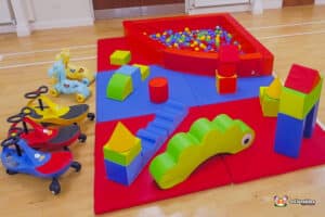 A cheerful play area filled with soft toys and a ball pool, designed for children to engage in creative and playful activities.