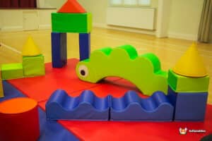 A lively play area with a big green and blue building, perfect for kids to enjoy creative and playful activities.
