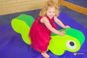 A lively play area where children are building with colorful blocks, with a ball pool nearby and no balls on the floor.