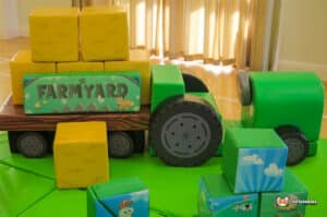 A lively soft play setup with a bright tractor and cute farm animals, perfect for a fun farm-themed experience for kids.