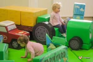 A cheerful soft play area showcasing a colorful tractor surrounded by friendly farm animals, ideal for children's playtime.