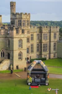 Playful inflatable castle with a fire pit and a wrecking ball, set in a sunny outdoor space, ideal for family fun.