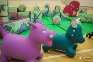 A colorful play area featuring a variety of toys, including a friendly dinosaur, inviting children to play and explore.