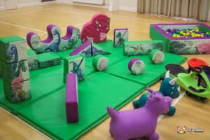 A vibrant play area filled with toys, highlighted by a cheerful dinosaur, perfect for imaginative playtime.