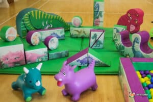 A playful scene showcasing a dinosaur among various toys in a bright play area, encouraging fun and creativity.