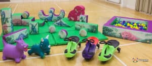 A vibrant play area filled with toys, including a friendly toy dinosaur at Dino Soft Play.