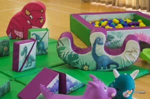 A lively play area with an assortment of toys, prominently featuring a dinosaur, designed for children's enjoyment.