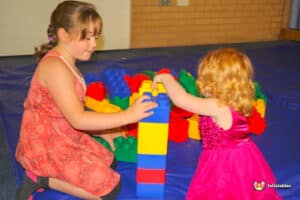 Two kids engaged in creative play with Edublocks Lego bricks, surrounded by colorful pieces.