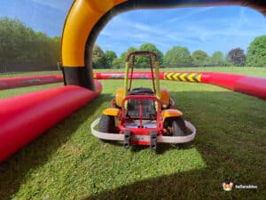A small go-kart resting on lush green grass, highlighting its playful appearance and compact size.