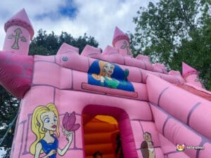 Bright pink bouncy castle with princesses painted on the entrance.