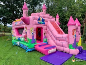 A cheerful princess castle bounce house with an attached slide, providing entertainment for kids at birthday celebrations.