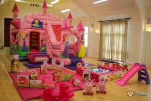 An enchanting pink bouncy castle paired with soft play equipment, designed for a delightful princess-themed experience.
