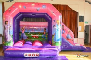 A lively bouncy castle decorated with princess illustrations, creating an enchanting play space for young children.