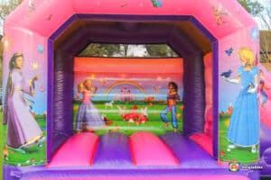 A cheerful bouncy castle decorated with princess illustrations, designed for children's enjoyment at a party or event.
