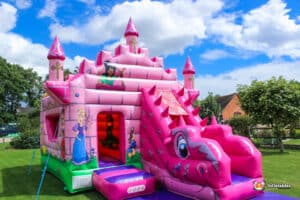 A whimsical pink castle with a slide, showcasing a princess, designed for a fairytale bounce and slide experience.