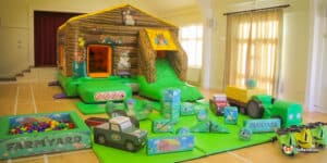 A lively play area showcasing a large inflatable farm-themed structure, filled with bright colors and playful designs.