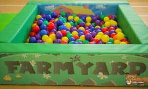 A farmyard image showcasing a sign that states "Farmyard" and includes a fun ball pool for children's play.