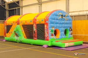 A colourful inflatable fun run 1 featuring cartoon characters engaged in sports and activities, set up in an indoor sports facility.