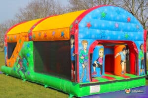 A colourful inflatable fun run 2 with vibrant designs featuring stars and playful characters, set on a grassy field.