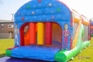 A colourful inflatable fun run 2 with star decorations, featuring bright pillars and playful cartoon characters on its sides.