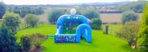 A vibrant inflatable bouncer designed for a golf chipping challenge, complete with a hole-in-one target for participants.