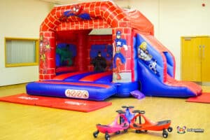 5. A bright bouncy castle featuring Spider hero like character designed for children to bounce and slide in a superhero-themed environment