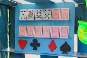 A display board showcasing playing cards arranged in rows, featuring various suits and a few colorful card shapes at the bottom.