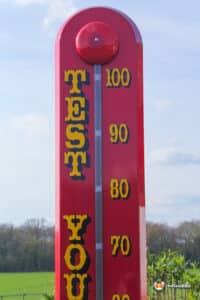 A red thermometer high striker, inviting people to test their strength.