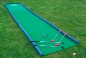 A vibrant miniature golf course scene with a green mat and a ball, showcasing a "Hole in 1" moment.
