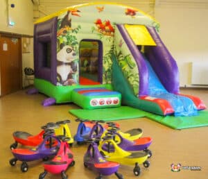 Jungle themed bouncy castle with plasma cars for fun.