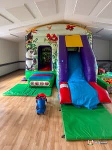 A children's play area with a slide, decorated with jungle animal motifs.